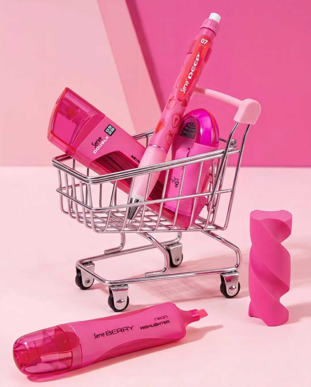 Pembe zeminde minik alışveriş sepeti içinde Serve Deep ve kalemtıraşlar